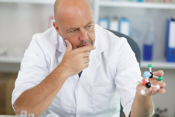 man scientist holding an atom model