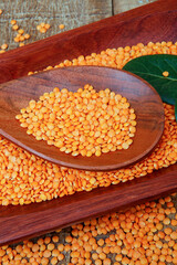 Pink lentil on wooden platter over rustic wooden table