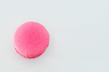 Pink French macaron isolated on white background. Tasty colourful macaroons. Cookie made of two smooth halves, fastened with stringy fillings. French pastry made from egg whites.
