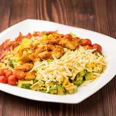 South western salad with cherry tomato, corn, cucumber, carrot and meat served in dish isolated on table top view green food