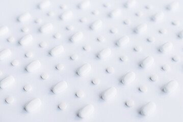 White pills on the white background