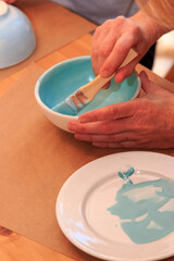 Eine Schale wird künstlerisch bemalt und verziert
