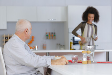young female caregiver preparing food for his employer