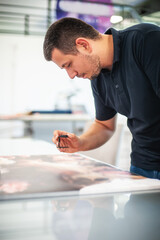 Young man in the process of printing used color scales and loupe and management color correction....