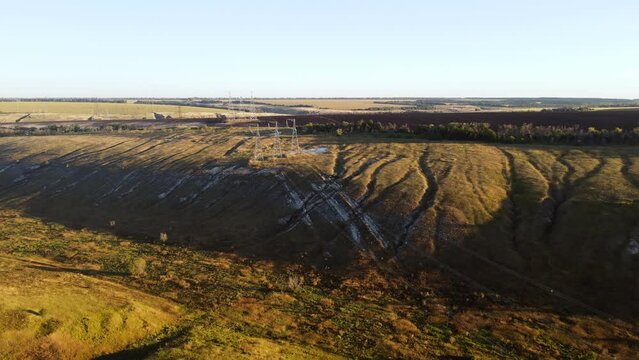 Establishing shot of country landscape with high voltage line and pilones aerial wide shot