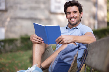 handsome man reading book outdoors