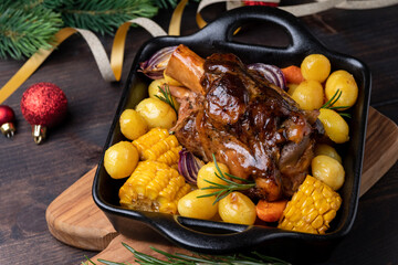 Holiday dinner food Pork shank  with baked potatoes and corn, festive food with Christmas New Year decor	