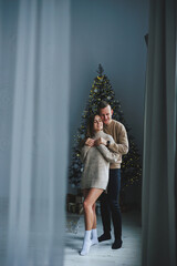 A couple in love enjoying each other on New Year's Eve. New Year's love story. A boy and a girl celebrate Christmas.