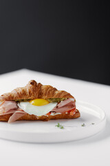 croissant with ham, egg, vegetables and avocado