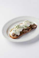 sandwich with poached egg and stew, drizzled with cheese and herbs