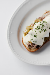 sandwich with poached egg and stew, drizzled with cheese and herbs