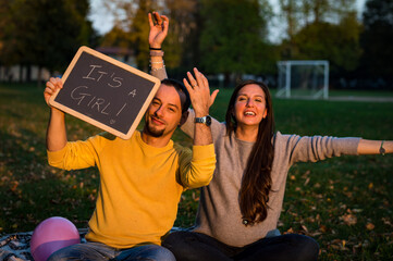 couple celebrates the birth of the baby in the park