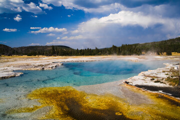 Steam rises over the colorful Sapphire Pool, a hot spring in Biscuit Basin, Yellowstone National Park, Wyoming.