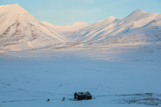 A skier pulls a ski sled to a backcountry cabin at the mouth of Foxdalen in Adventdalen, Svalbard.