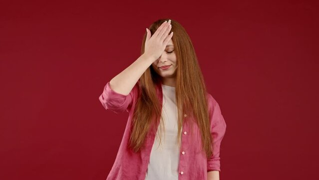 Worried woman doing face-palm gesture, like no, I forgot. Disappointed girl feeling sorrow, regret, drama, failure, problems on red background.