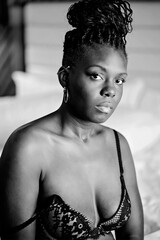 Black woman sitting on bed in deep thought