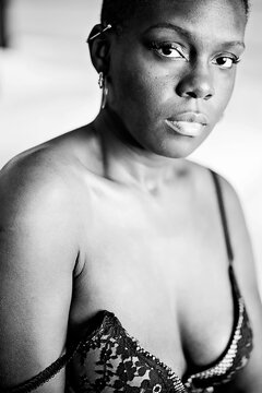 Black woman sitting on bed in deep thought