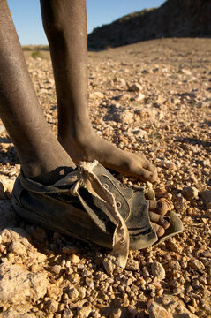 Himba boy with one worn out shoe, Namibia.