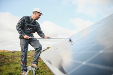 Worker cleaning solar panels after installation outdoors