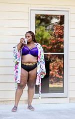 Black woman outside having tea with robe panty and bra on