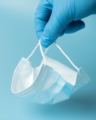 Fototapeta premium Medical protective mask on a blue background, coronavirus prevention, virus protection factor. Medical or surgical face mask. Virus protection. Respiratory respiratory mask.