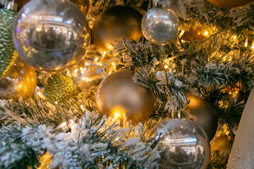 Fototapeta na wymiar Lots of gold and silver Christmas balls on the Christmas tree. Christmas decorations. Festive Christmas toys. Close-up.