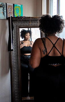 Black woman admiring herself in the mirror