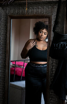 Black woman admiring herself in the mirror