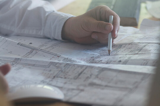 Cropped image of a businessman with pencil working on blueprint in the office, Freiburg im Breisgau, Baden-W&uuml;rttemberg, Germany