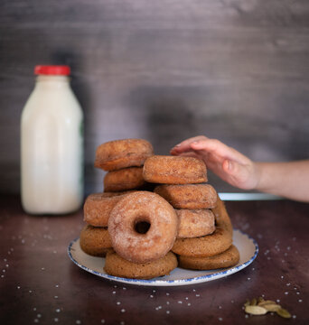 Child's hand reaching for cider donut