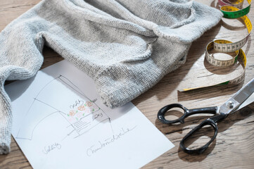 Cardigan with haberdashery items on wooden table, Bavaria, Germany