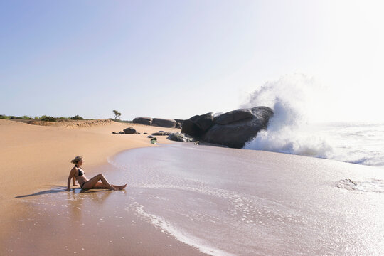 Woman relaxing on the beach, Western Province, Sri Lanka