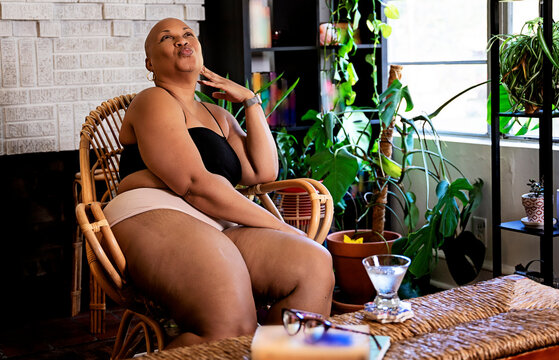 Black Woman enjoying the day in her home surrounded by plants
