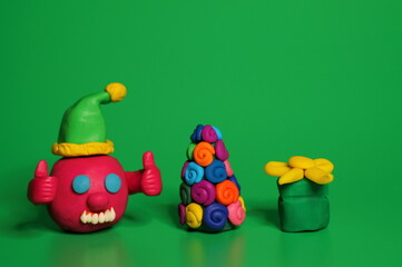 Fototapeta na wymiar A virus figurine with thumbs up. Green background. Christmas toys.