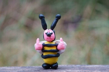 A figure of a funny smiling bee. A toy with thumbs up. Gesture class. Positive attitude.  A symbol of spring.