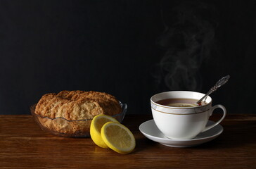 tea with lemon and cookies on a table on a dark background