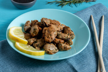 mussels with noodles boiled in a plate with spices on a blue background