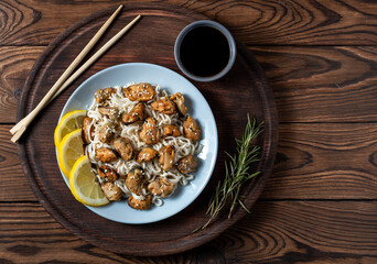 mussels with noodles boiled in a plate with spices on a wooden background