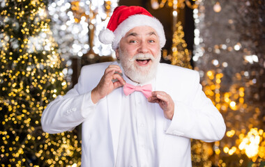Being surprised. happy mature man white formal suit. successful businessman fix event tuxedo tie. senior man santa christmas light illuminated background. bright and festive xmas mood. new year party