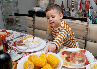 excited little boy sitting at the thanksgiving table