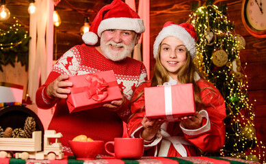 Believe in Santa Claus. Santa bring gifts little girl. Cheerful celebration. Child enjoy christmas with bearded grandfather Santa claus. Happiness and joy. Festive tradition. Santa Claus exists