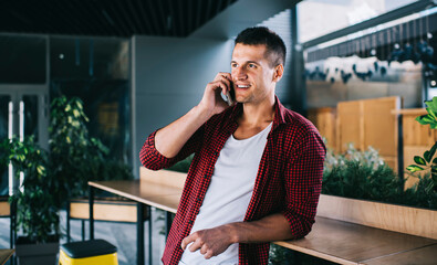 Young handsome male having mobile phone conversation. 30 years old man calling via smartphone for communicate. Successful businessman talking on cellphone