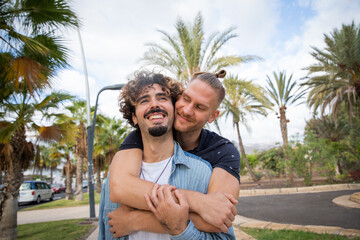 A same-sex couple hugs and smiles, affection between same-sex partners.