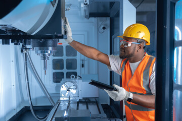 Industry Control and Setting of CNC equipment, Engineer african with tablet computer work on modern automatic machine