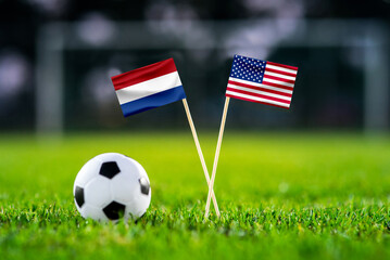 Netherlands - United States of America. Eight final, Last 16 football match. Handmade national flags and soccer ball on green grass. Football stadium in background. Black space. USA soccer match