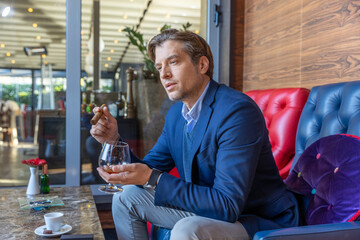 Handsome man in casual suit relaxing in hotel lobby
