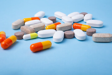 Front view of different pills on blue background,copy space for text.