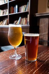 Pint glasses of british ale and lager beer served in old vintage English pub