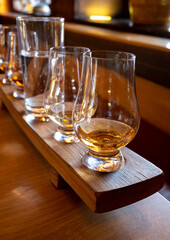 Flight of single malt scotch whisky in glasses served in whiskey bar in Edinburgh, UK