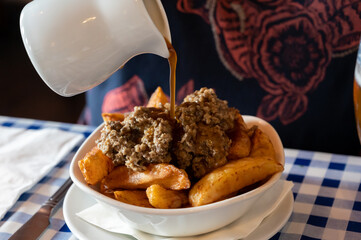 Scottish traditional snack food, hand cut potato chips topped with haggis and gravy